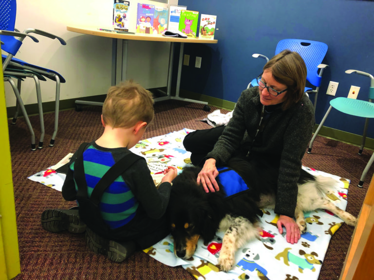 Reading to a dog is fun and educational for children at Lakeview Library